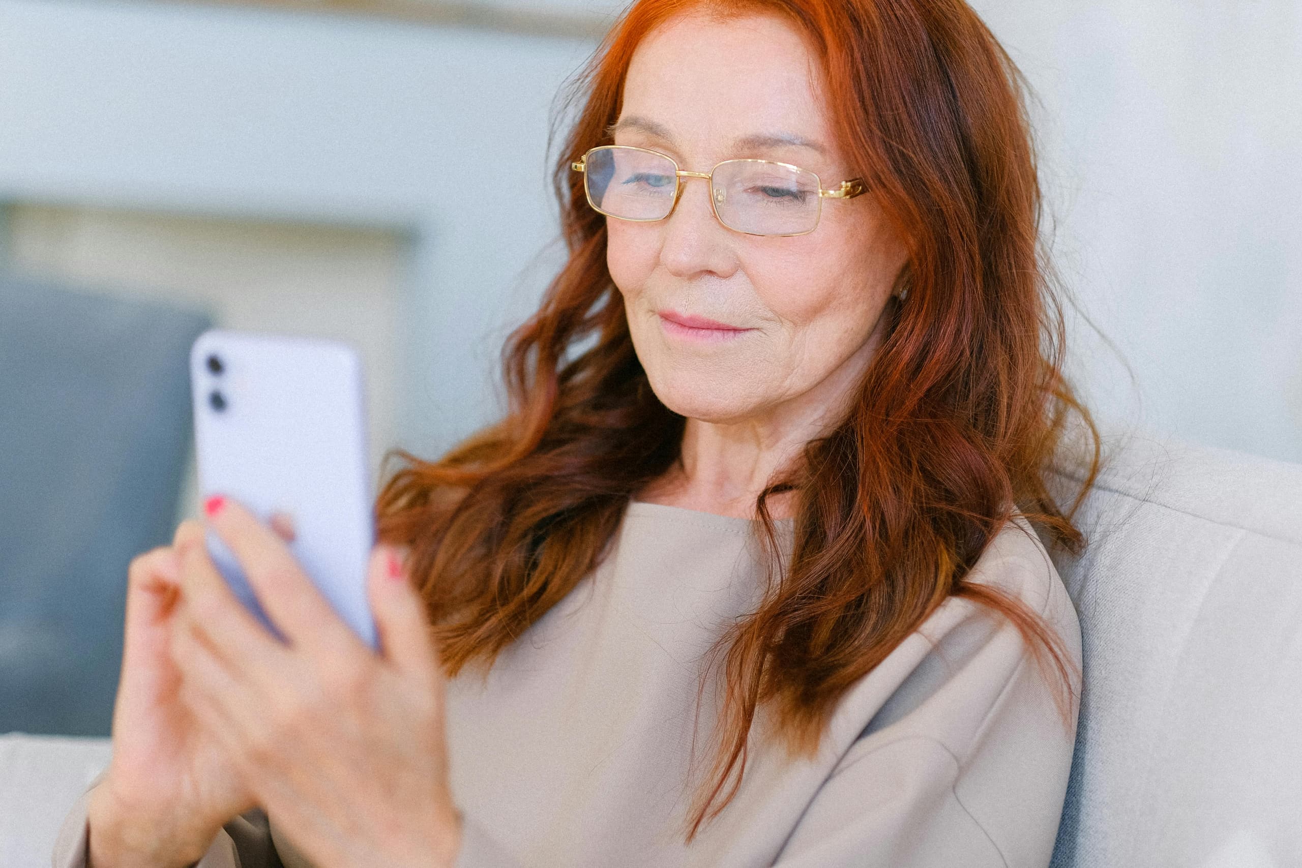 Frau mit Brille liest auf ihrem Smartphone