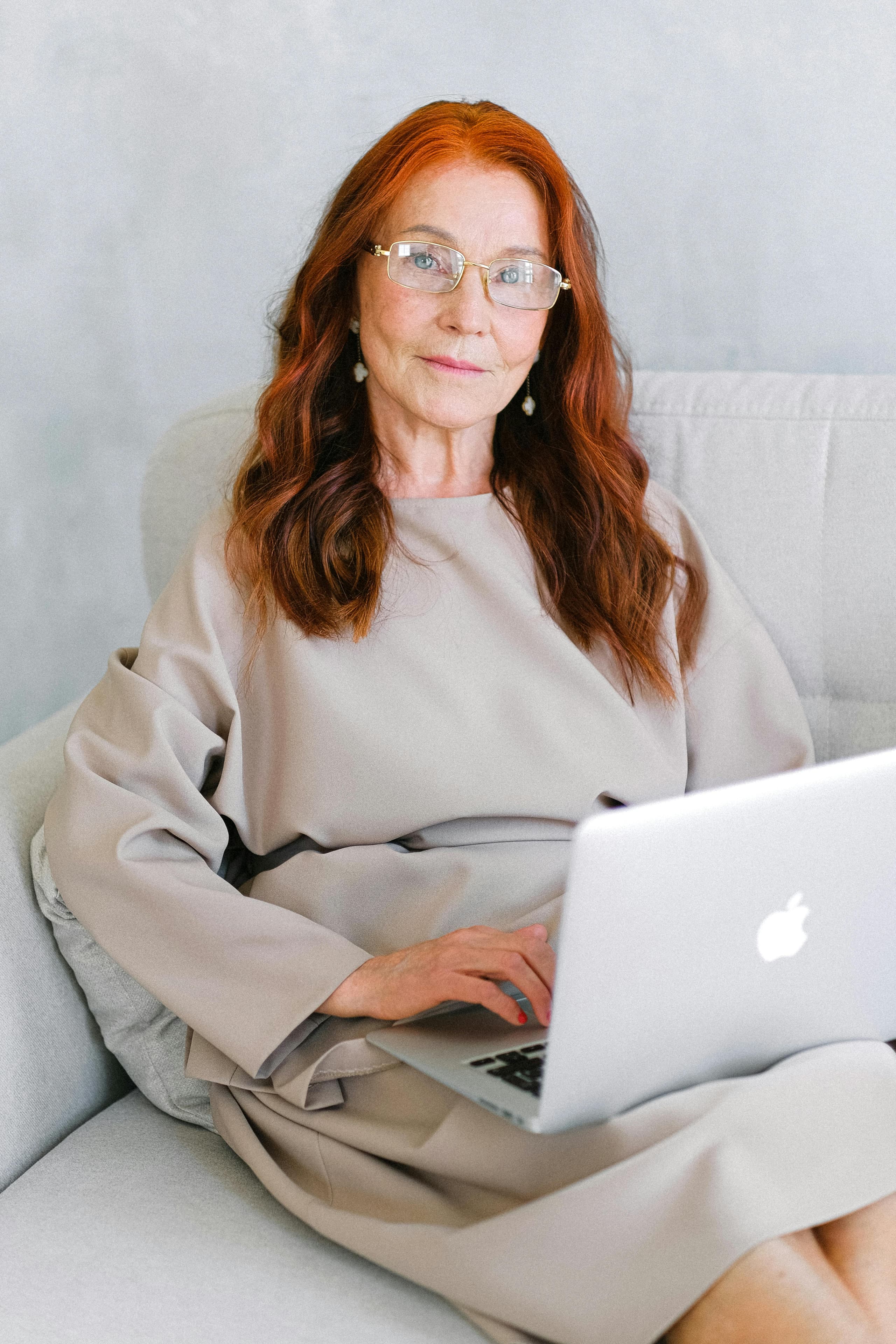 Frau arbeitet auf einem Sofa am Laptop
