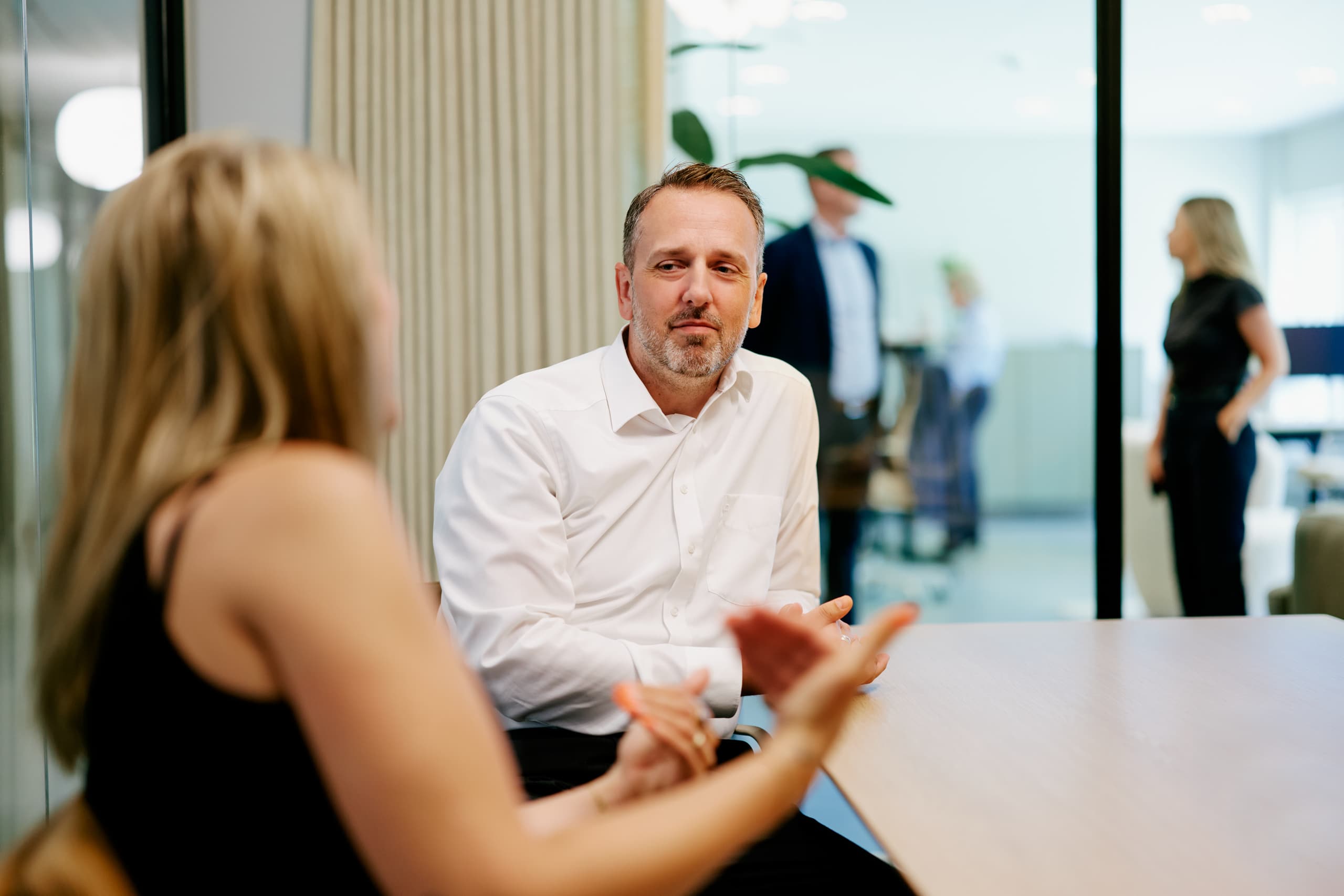 Mann im weißen Hemd hört in einem Meeting aufmerksam zu
